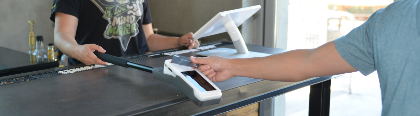 Merchant taking a payment on a Clover contactless card machine